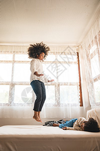 非裔美国儿童在家里的床上玩耍放松图片