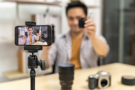 使用手机录制活体vlog视频网络上关于社交媒体概念的透气器聚焦于相机背景图片