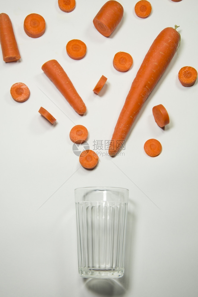 新鲜的胡萝卜汁流到玻璃杯里图片