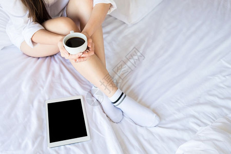 早晨美女在卧室的床上喝着咖啡图片