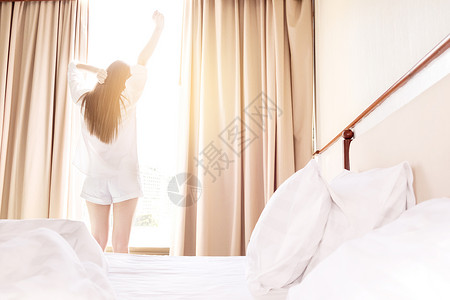 美女早晨起床在窗前拉伸图片