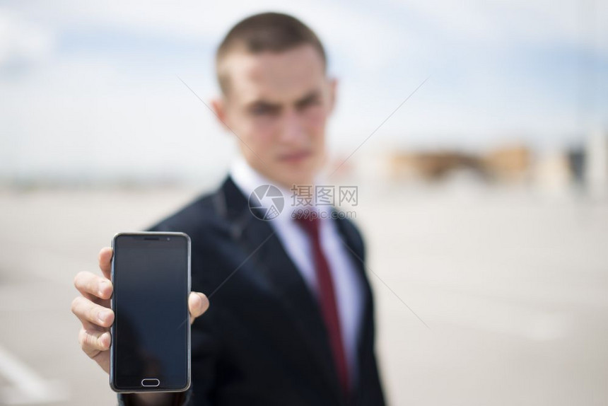 年轻商人显示智能手机屏幕的年轻商人图片