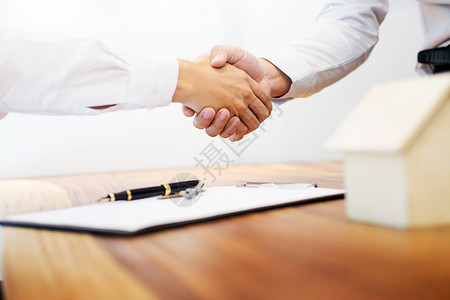 房地产代理商在签订合同作为房地产代理办事处的成功协议之后与客户握手背景图片