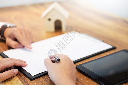 与银行工人或房地产代理商会晤签署客户合同商定条件和经批准的申请分析房贷估价和背景图片
