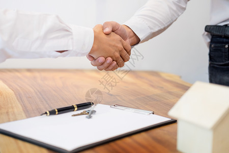 房地产代理商在签订合同作为房地产代理办事处的成功协议之后与客户握手购房和保险的概念背景图片