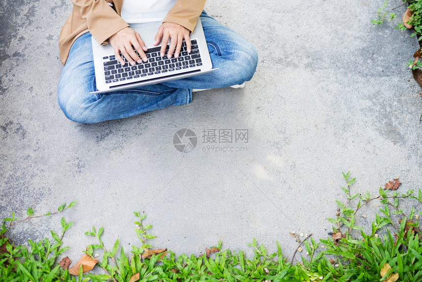在花园桌上使用笔记本电脑的妇女手图片