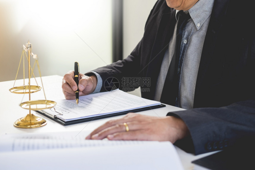 法官在书桌旁的庭上宣读和写文件图片