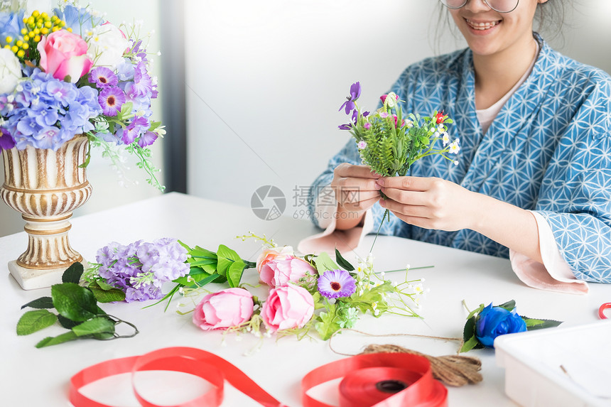 年轻女孩花卉店主在其商手工艺品和制作中图片