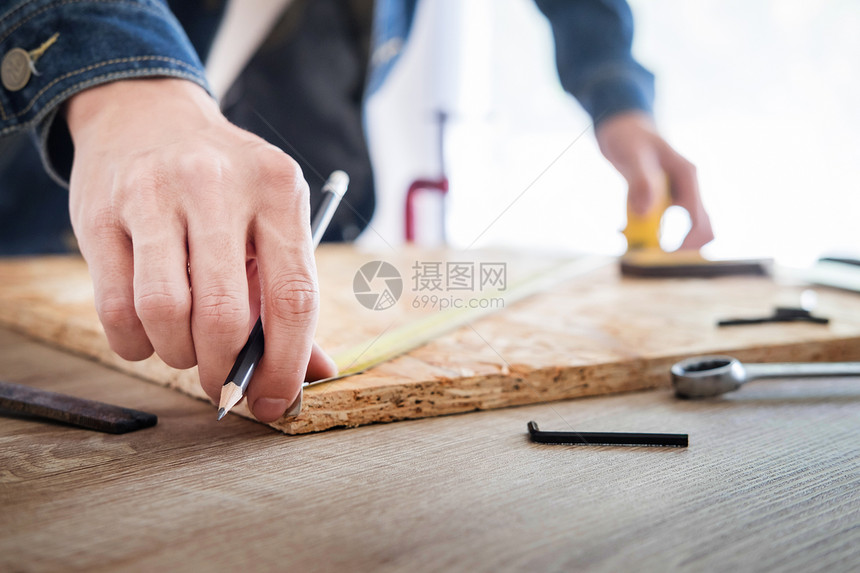 木匠仔细研究工程在工作场所切割木板图片
