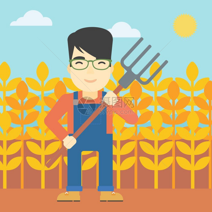 一位手持草叉站在小麦田背景的农民图片