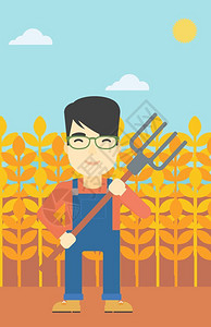 手持草叉站在小麦田里的农民图片