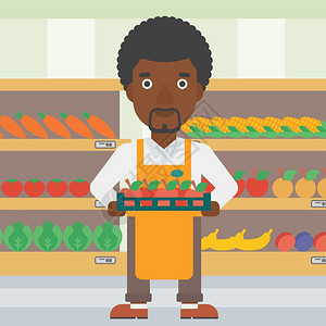 在超市货架旁端着一盘苹果的非裔员工图片