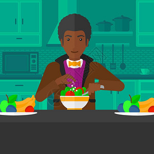 在厨房中做蔬菜沙拉的非裔男子图片