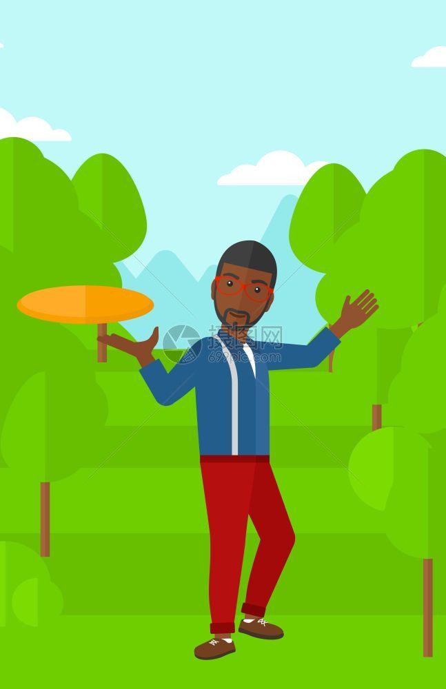 一名在绿草坪上玩飞盘的非裔男子图片