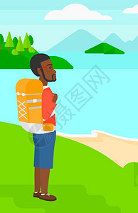 站在山顶上享受海景背包徒步的男人图片