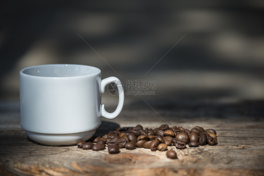 木桌上的咖啡杯和咖啡豆图片