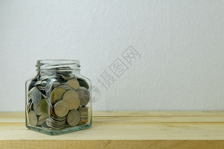 玻璃瓶里的硬币花在玻璃瓶里存钱换背景