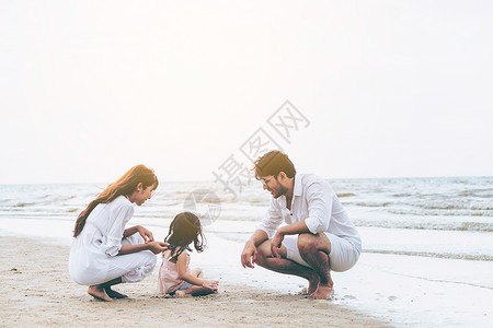 父母带着女儿在海边玩耍图片