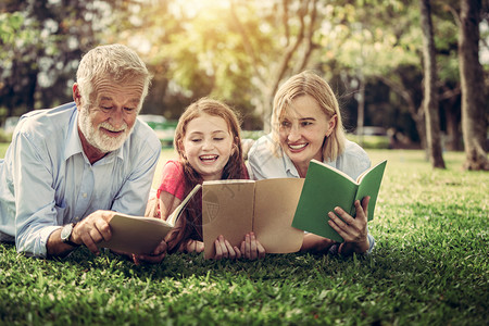 快乐的家庭在公园草地看书学习图片