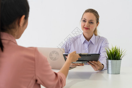 两名青年商业妇女在办公室桌开会讨论图片
