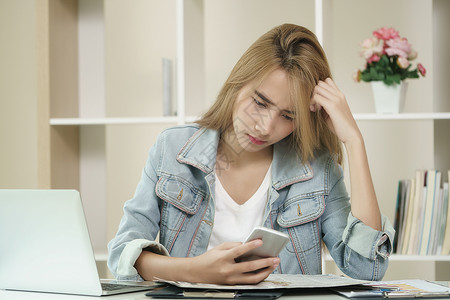 女人看着手机屏幕时感到不开心图片