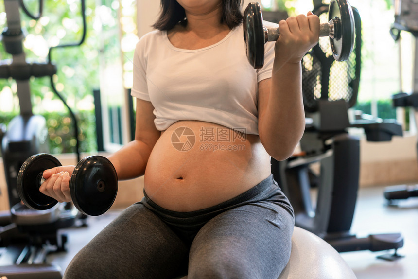 年轻孕妇在做身体锻炼图片