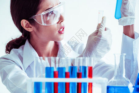 在实验室工作并检查试管生物化学样本的女科家技术研究和发展概念图片