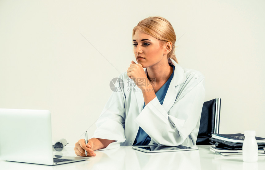 女医生在办公室桌子上撰写医疗报告图片