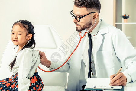 医生认真听诊为小孩做检查图片