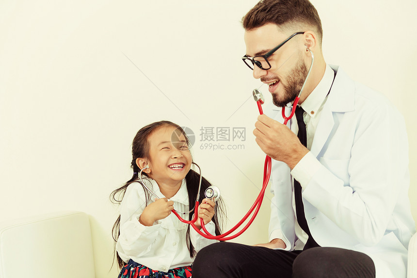 医生教孩子愉快的玩助听器图片