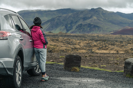 旅行者倚靠着车并享受山地风景图片