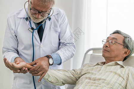 医生在病房讨论和检查老年病人的健康状况图片
