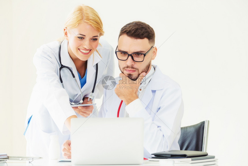 高级男医生使用笔记本电脑与另一名人员医务进行讨论图片