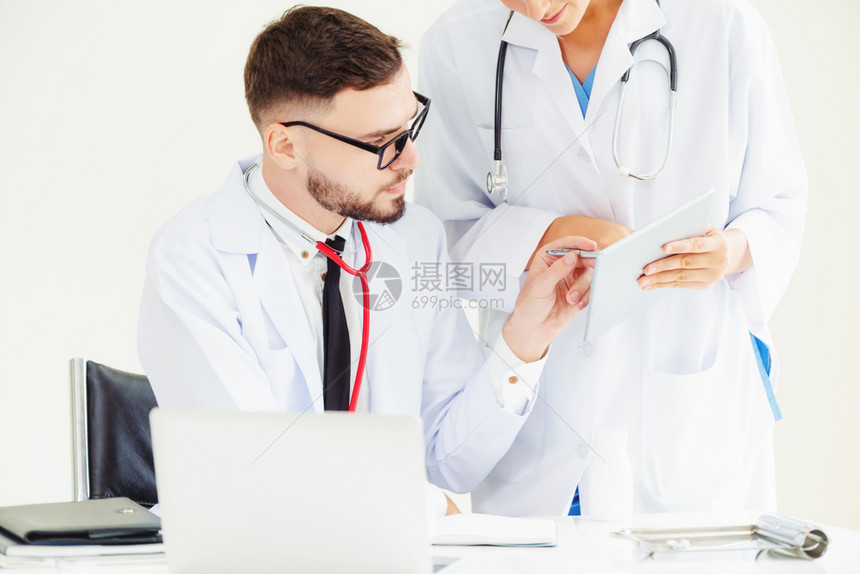 高级男医生使用笔记本电脑与另一名人员医务进行讨论图片