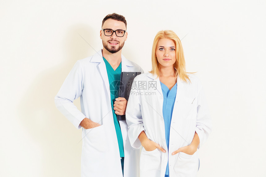 有自信的外科医生持有文件剪贴板同时与另一名白背景医生站在一起医疗服务和保健人员概念图片