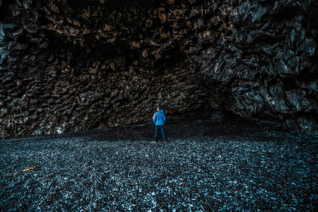 在火山黑岩洞穴的旅行爱好者高清图片