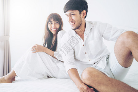 快乐的年轻夫妇在早晨醒来后家庭卧室放松背景图片
