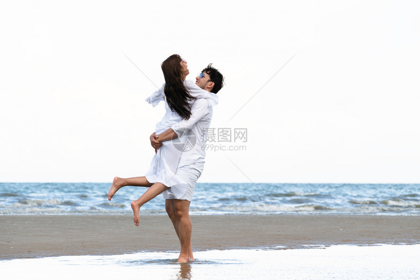 快乐的情侣在夏天去热带沙滩渡蜜月图片