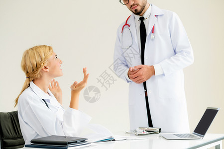 年轻女医生与一个男医生交谈专业团队的概念图片