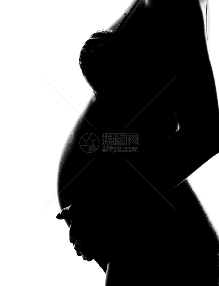 赤裸身的怀孕妇女抱腹部的轮廓图片