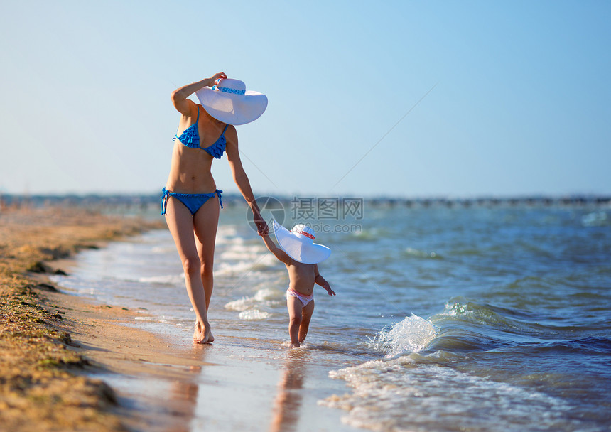 在海滩上散步的母女图片