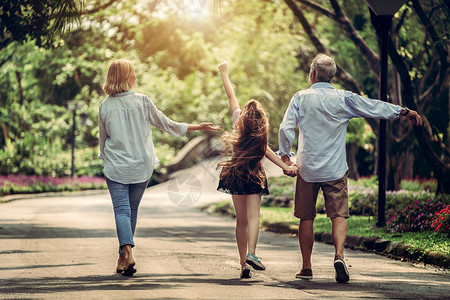快乐的幸福家庭夏天在公园的路上一起走图片