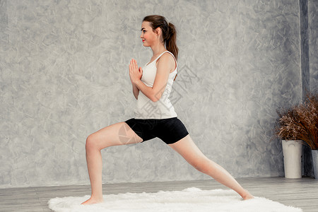 年轻美女在客厅做瑜伽锻炼和放松背景图片