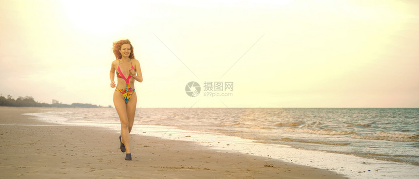 夏季在热带沙滩上奔跑的年轻女跑者图片