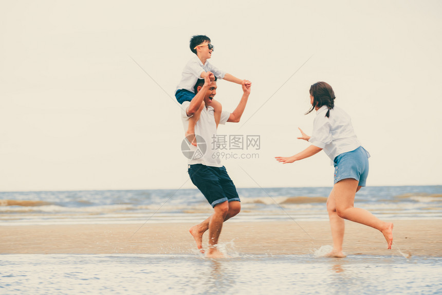 夏天幸福的家庭父母和儿子在热带沙滩上度假图片