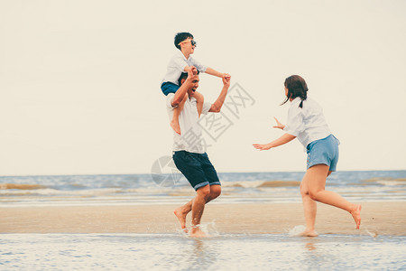 夏天幸福的家庭父母和儿子在热带沙滩上度假图片