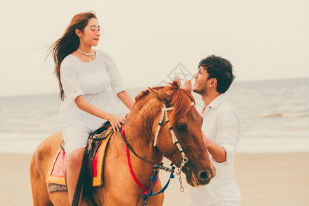 年轻夫妇暑假在热带海滩骑马度蜜月图片