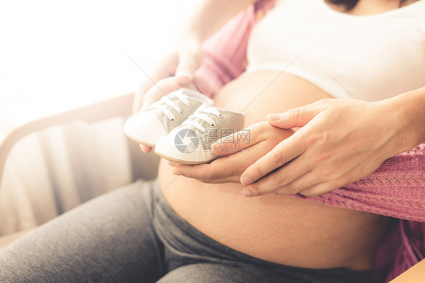 怀孕夫妇妻在家里感到爱和放松年轻孕妇在怀期间有婴儿父亲照顾怀孕母和怀孕护理的概念图片