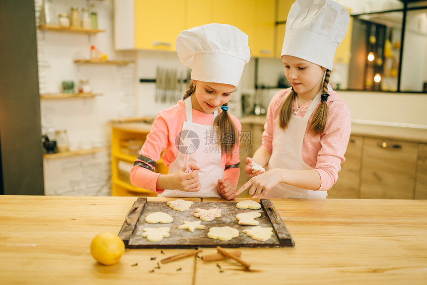两个小女孩准备送饼干到烤箱里图片