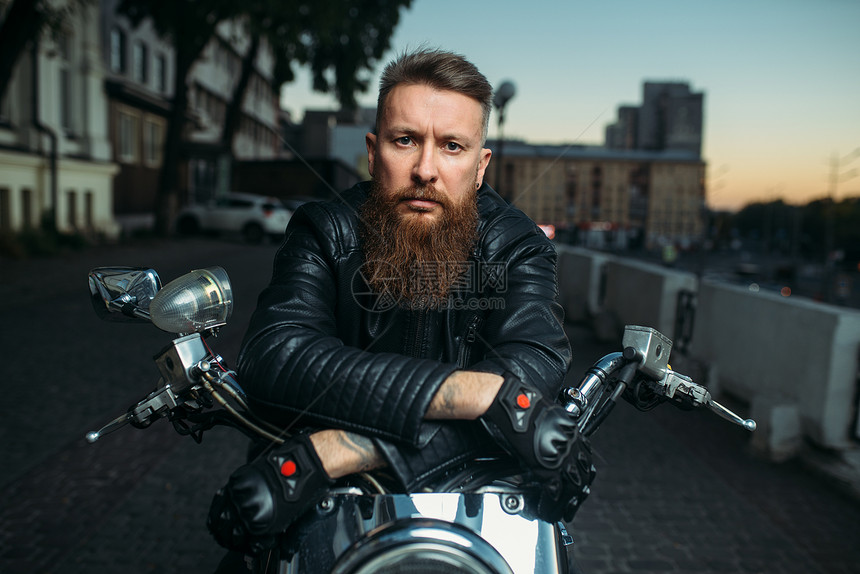 骑古典摩托车的摩托车手前视图图片